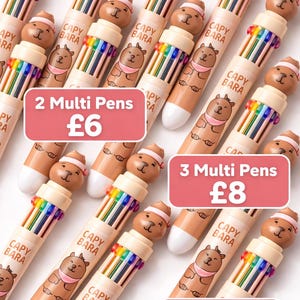 May include: Multiple multi-color pens with bear-shaped toppers. Each pen has a rainbow of colors and the text "CAPY BARA". The image includes text indicating the number of pens available.