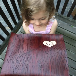 May include: A brown leather placemat with a wood grain pattern. A small white heart with the text "K+Z" is in the center of the placemat.
