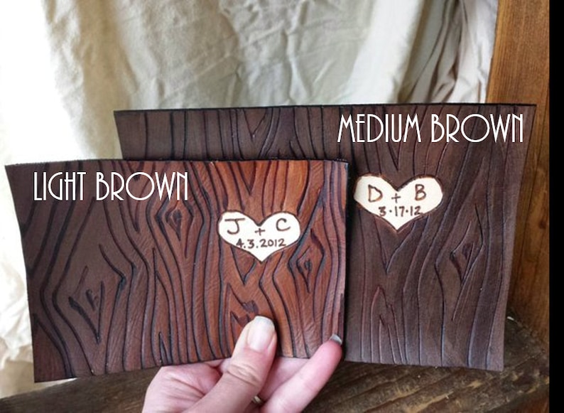 May include: Two leather samples in light brown and medium brown with a wood grain texture. The samples are engraved with hearts and initials, "J + C 4.3.2012" and "D + B 3.17.12".