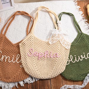 May include: Three crochet tote bags in brown, beige, and green. Each bag features a name in a contrasting color: "Emily", "Sophia", and "Olivia". The bags have long handles and a net-like weave.