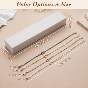 K&ouml;nnte beinhalten: Draufsicht auf eine wei&szlig;e rechteckige Schachtel und vier filigrane Kettenarmb&auml;nder in Schwarz, Gold, Ros&eacute;gold und Silber. Die Armb&auml;nder sind ca. 23 cm lang. Der Text "Color Options & Size" befindet sich oben.