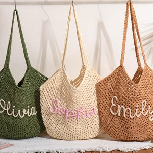 May include: Three crochet tote bags in olive green, cream, and brown, each with a name embroidered on the front: Olivia, Sophia, and Emily. The bags have long handles and a woven design, perfect for carrying items.