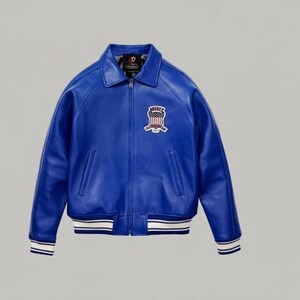 May include: A vibrant blue leather jacket featuring a classic collar, a full-length front zipper, and two side pockets. On the left chest, there is a patch displaying an American flag shield with the text AVIREX. The cuffs and hem have white stripes.