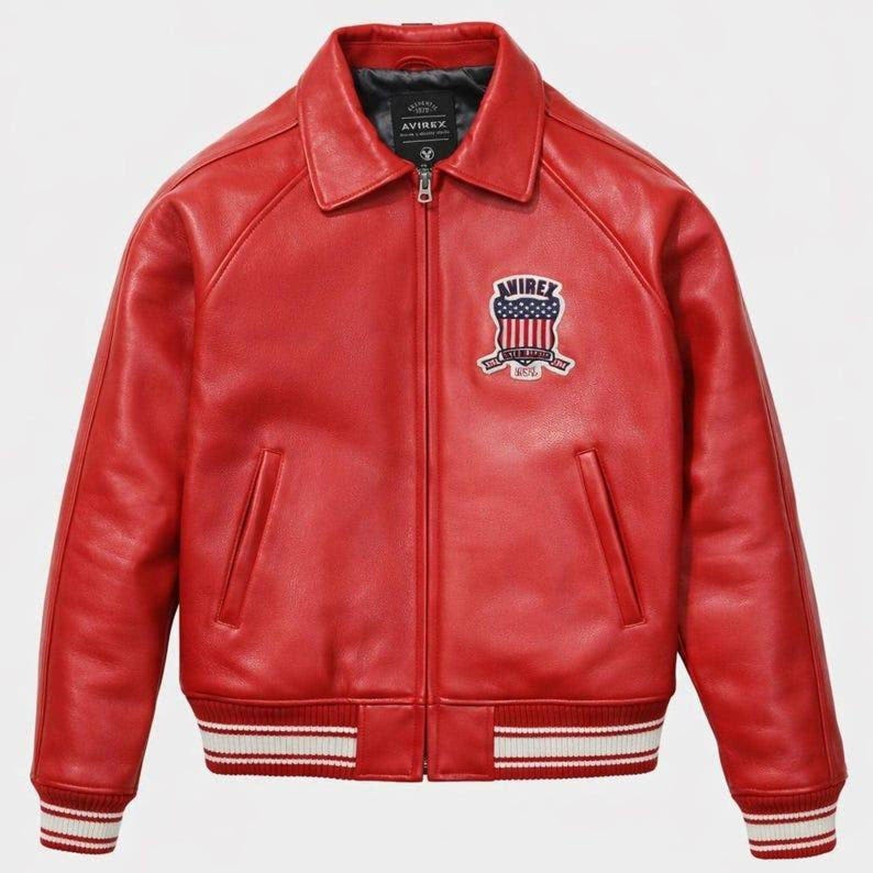 May include: A vibrant red leather jacket with a zip-up front and a collar. The jacket features a patch on the chest and white and red striped cuffs and hem. The patch displays the text "AVIREX" and a patriotic design.