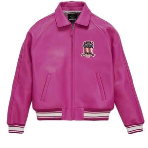 Puede incluir: Chaqueta de cuero fucsia vibrante con silueta bomber cl&aacute;sica. Cuello camisero, cremallera frontal y bajo y pu&ntilde;os acanalados con rayas blancas y burdeos. Parche bordado con dise&ntilde;o de bandera americana en el pecho.