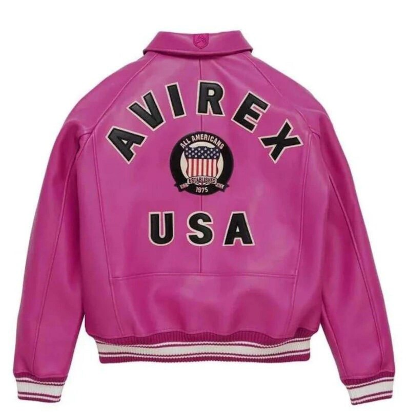 Puede incluir: Una chaqueta de cuero fucsia vibrante con la palabra "AVIREX" arqueada en la espalda en letras negras. Debajo del nombre de la marca hay un parche circular con las palabras "ALL AMERICANS" y "USA" en blanco. La chaqueta tiene un ribete a rayas blancas y negras.