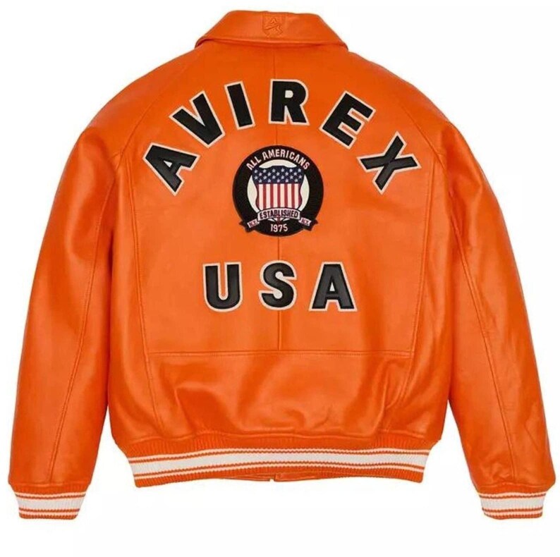 May include: A bright orange varsity jacket featuring the black text AVIREX arched across the upper back. Below the text is a circular patch with a flag graphic and the words ALL AMERICANS ESTABLISHED 1975. The word USA is printed in large black letters.