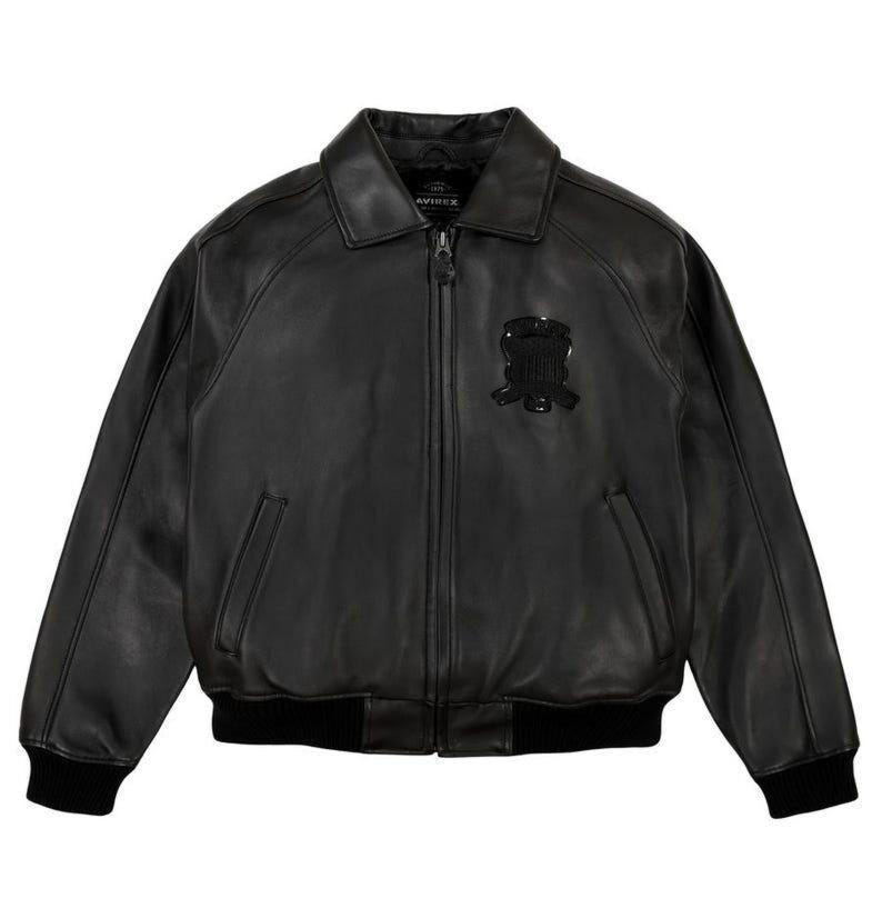 May include: Black leather jacket with a collared neckline, a zipper closure, and a black emblem on the chest. The jacket has two front pockets and ribbed cuffs and hem. The jacket is a classic style.