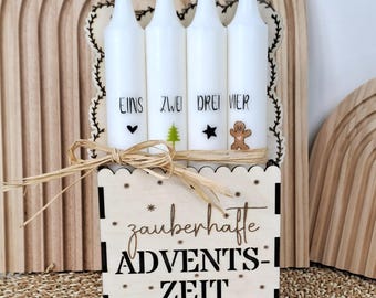 May include: Wooden Advent calendar featuring four white candles, each marked with a number and a small icon. The wooden box below displays the text "zauberhafte ADVENTS-ZEIT" with star accents, tied with a raffia bow.