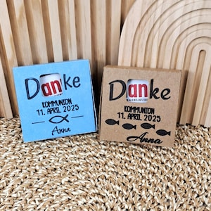 May include: Two small gift boxes, one blue and one brown, with the German word "Danke" and the date "11. April 2025" printed on them. The blue box has a fish symbol and the name "Anna". The brown box has fish illustrations.