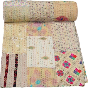 Peut inclure: Une courtepointe patchwork avec un bord supérieur roulé. La courtepointe présente une variété de tissus à motifs dans des couleurs crème, beige et pastel. Le design comprend des motifs floraux, géométriques et abstraits, avec des coutures visibles.