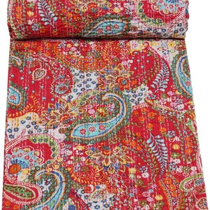 Peut inclure: Une courtepointe paisley rouge enroulée avec un motif floral vibrant dans les tons d'orange, de jaune, de bleu et de vert. La courtepointe présente des coutures complexes partout, ajoutant de la texture et des détails au design. Cette courtepointe décorative est parfaite.