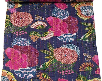 Könnte beinhalten: Eine marineblaue Steppdecke mit einem lebendigen Blumenmuster. Das Design zeigt große, stilisierte Blumen in Rosa, Gelb und Weiß, vor einem dunkelblauen Hintergrund. Die Steppdecke ist gefaltet und zeigt die detaillierten Nähte.
