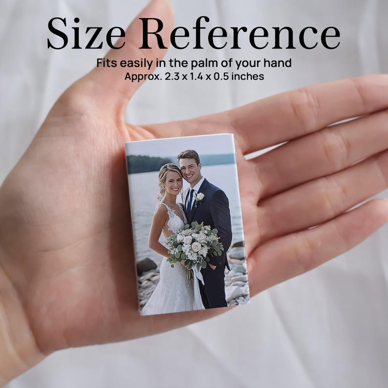May include: A small rectangular block featuring a printed photograph of a couple in wedding attire. The text reads Size Reference, Fits easily in the palm of your hand, Approx. 2.3 x 1.4 x 0.5 inches. The object is held in an open palm.
