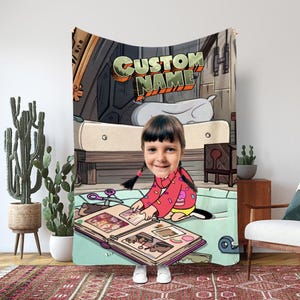 Könnte beinhalten: Individuelle Decke mit einem Cartoon-Hintergrund und dem Text "CUSTOM NAME". Die Decke zeigt ein Foto einer Person vor einem offenen Fotoalbum. Die Decke ist über eine Person drapiert.