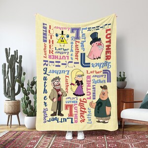 Könnte beinhalten: Eine hellgelbe Decke mit Cartoon-Charakteren und dem Wort "Luther" in verschiedenen Schriftarten und Farben. Die Decke hat ein gitterartiges Muster und zeigt ein Schwein mit Zylinder, ein gelbes Dreieck und andere Charaktere.