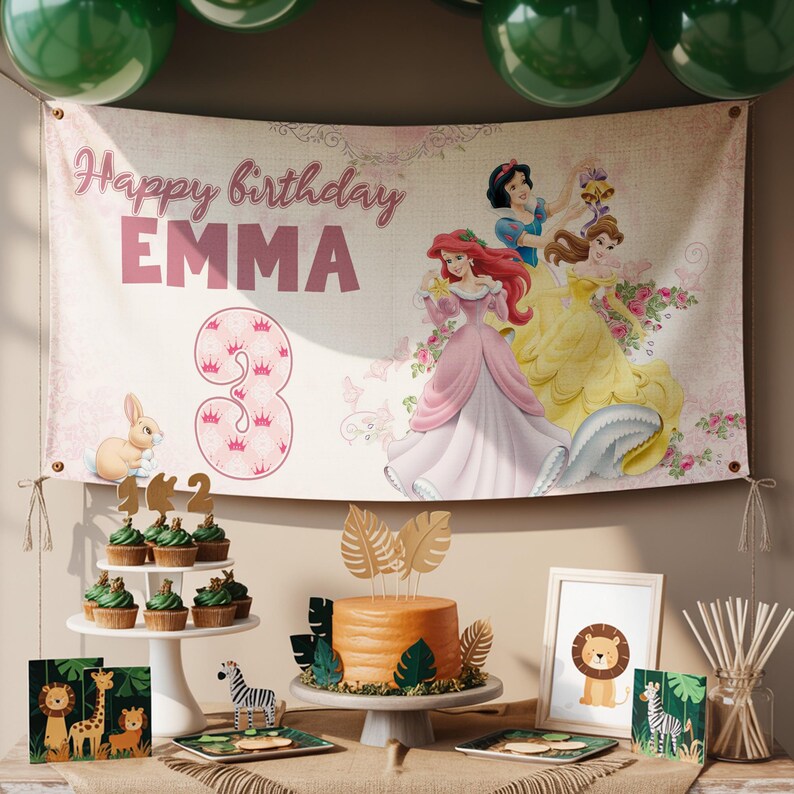 May include: A birthday party banner with the text "Happy birthday EMMA" and the number "3". The banner features illustrations of Disney princesses and a bunny. The party also includes cupcakes, a cake, and animal-themed decorations.