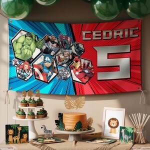 K&ouml;nnte beinhalten: Ein Banner mit dem Namen "Cedric" und der Zahl "5" in Silber, mit Comic-Helden auf blauem und rotem Hintergrund. Der Party-Tisch umfasst Cupcakes, einen Kuchen und Dekorationen mit Tiermotiven.