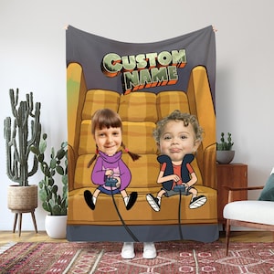 Könnte beinhalten: Personalisierte Decke mit einem Cartoon-Bild von zwei Kindern, die Videospiele auf einem gelben Sofa spielen. Die Decke zeigt den Text "CUSTOM NAME" in einem Retro-Stil. Die Gesichter der Kinder sind überlagert.