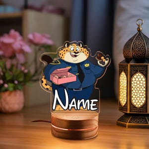 May include: A white ceramic mug with a black handle and the text "But First, Coffee" in a black, handwritten-style font. The mug is on a white surface.