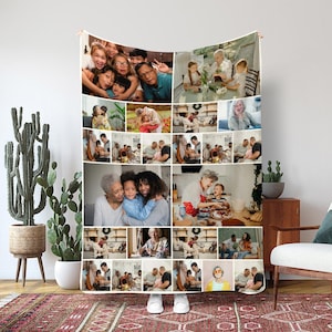 May include: A white fleece blanket displaying a collage of family photographs. The images show various family members in different settings, including group shots and individual portraits. The blanket is shown against a neutral backdrop.