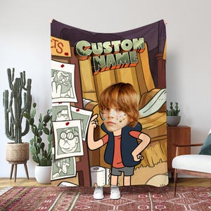 Könnte beinhalten: Eine personalisierte Decke mit einem Cartoon-Design und dem Text "CUSTOM NAME". Die Decke zeigt eine Cartoon-Illustration eines Jungen vor einem braunen und lila Hintergrund. Die Decke wird in einem Raum mit einem Kaktus und einem Teppich ausgestellt.