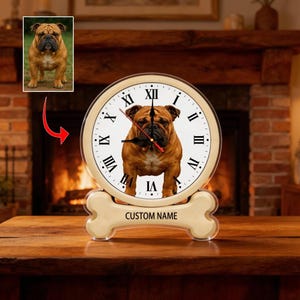Könnte beinhalten: Eine cremefarbene Uhr mit einem braunen Bulldoggenbild auf dem Zifferblatt und schwarzen römischen Ziffern. Die Uhr steht auf einem knochenförmigen Sockel mit dem Text "CUSTOM NAME". Ein zusätzliches Bild des Bulldogs befindet sich in der oberen linken Ecke.