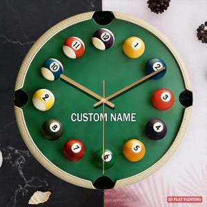 May include: A round wall clock with a green face, featuring billiard balls as hour markers. The clock has a beige border and gold-colored hands. The text "CUSTOM NAME" is printed on the clock face. The clock is a 2D flat painting.
