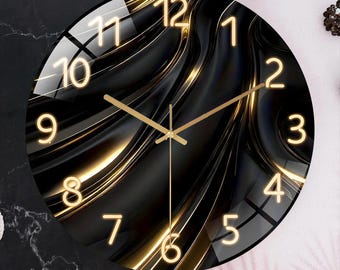 May include: A round wall clock with a black and gold abstract design. The clock face features gold numerals and hands against a dark background with flowing, wave-like patterns. The clock's diameter is approximately 12 inches.