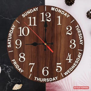 May include: A round wooden wall clock with a dark brown finish. The clock face features white numerals and the days of the week. The hour and minute hands are black, and the second hand is red. The clock is labeled "2D FLAT PAINTING".