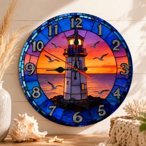May include: A round wall clock featuring a stained glass style design of a lighthouse at sunset. The clock face displays a vibrant orange and purple sky over a dark blue ocean with flying seagulls. It has black hands and large silver numbers.