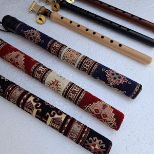 Puede incluir: Una colección de flautas duduk de madera en varios colores, incluyendo madera natural, negro y marrón. Las flautas tienen agujeros para los dedos y están acompañadas de estuches decorativos en rojo, azul y negro con diseños estampados.