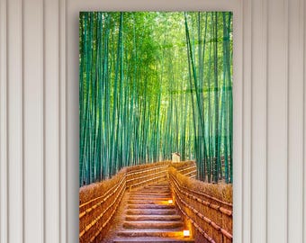 Può includere: Una grande stampa incorniciata di una foresta di bambù con una passerella in legno. L'opera d'arte è appesa sopra un moderno divano componibile in un soggiorno. Le pareti sono bianche con modanature decorative.