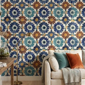 May include: A living room scene featuring a patterned wallpaper with blue, teal, and brown floral designs. A wooden table, a sofa with colorful pillows, and a floor lamp are in the room. A wooden clock and decorative items are on a shelf.