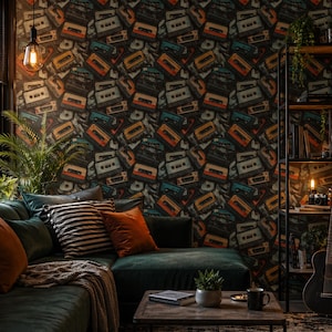 May include: A living room with a dark green sectional sofa, throw pillows, and a wooden coffee table. The wall is covered in wallpaper with a repeating pattern of vintage cassette tapes in various colors. A guitar and bookshelf are visible.