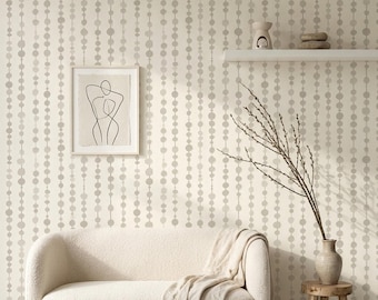 Könnte beinhalten: Ein Wohnzimmer in neutralen Tönen mit einem cremefarbenen Sofa und einer weichen Decke. Ein Beistelltisch aus Holz trägt eine Vase mit Zweigen. Die Wand ist mit einer Tapete mit sich wiederholendem Punktmuster und einem gerahmten Kunstdruck geschmückt.