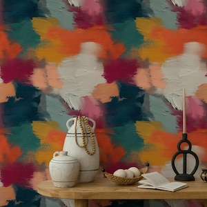 Può includere: Carta da parati astratta con un vivace mix di colori tra cui pennellate arancioni, verde acqua, rosa e bianche. Un tavolo di legno espone vasi decorativi, un candeliere, un piccolo cestino con palline e un libro aperto. Il tema generale è l'arredamento della casa.