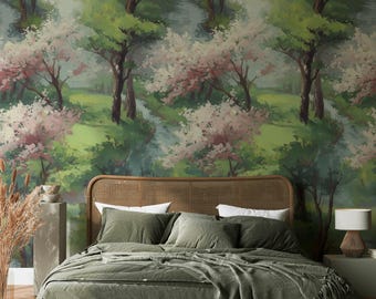 May include: A bedroom with a green bedspread, pillows, and a woven headboard. The wall behind the bed features a mural of a forest scene with trees, a stream, and pink and white blossoms. A lamp sits on a side table.