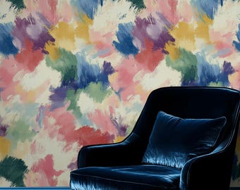 May include: A navy blue velvet armchair with a matching cushion sits in front of a wall covered in colorful abstract brushstrokes. The wallpaper features a mix of pink, blue, green, and yellow hues.