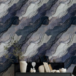 May include: Abstract wallpaper with a layered, textured design in shades of blue, gray, and white. The pattern resembles a stylized landscape or rock formation. The wallpaper is installed behind a dark gray cabinet with decorative items.