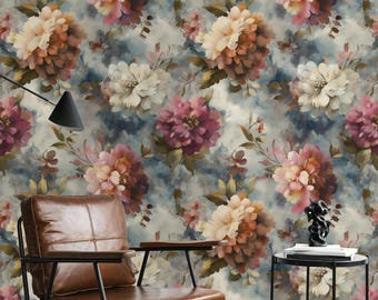 May include: Wallpaper with a repeating floral pattern of large, watercolour-style blooms in cream, peach, and burgundy against a soft blue backdrop. A brown leather armchair with a black metal frame is in front of the wallpaper, with a small side table.