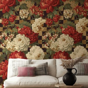 May include: A living room scene featuring a white sofa with patterned pillows, a black vase with dried plants, and a wooden side table. The backdrop is a floral wallpaper with red and cream-colored peonies.