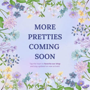 May include: A floral-themed graphic with the text "MORE PRETTIES COMING SOON." The design features a variety of flowers in shades of purple, blue, yellow, and white, arranged around the text. The text encourages viewers to favorite the shop.