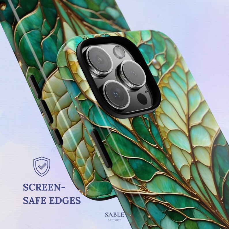 May include: A close-up of two phone cases with a leaf design in shades of green and gold. The cases have a glossy finish and a black camera frame. The text "SCREEN-SAFE EDGES" is visible on the left side of the image.