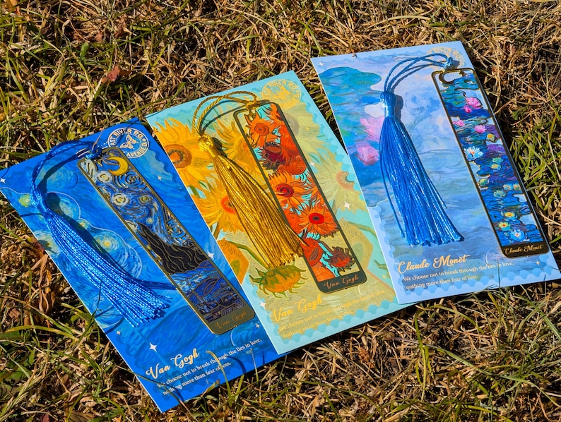 Puede incluir: Cuatro marcadores decorativos con impresiones de arte famosas. Los marcadores tienen borlas coloridas y est&aacute;n tematizados con pinturas de Van Gogh y Claude Monet. Los marcadores est&aacute;n sobre hierba.