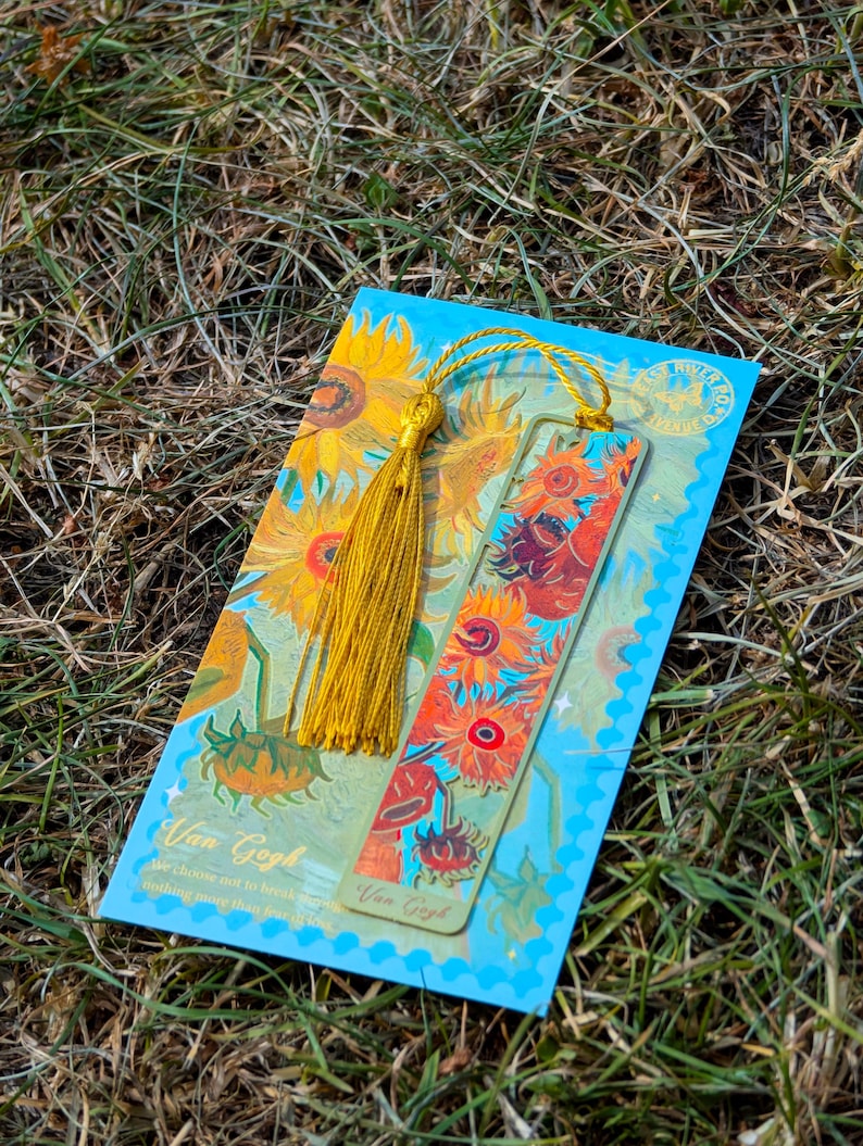 Puede incluir: Un conjunto de marcap&aacute;ginas y tarjetas con un dise&ntilde;o de girasoles inspirado en Van Gogh. El marcap&aacute;ginas tiene una borla dorada. La tarjeta tiene el texto "Van Gogh" y una cita. La paleta de colores incluye amarillo, naranja y azul.