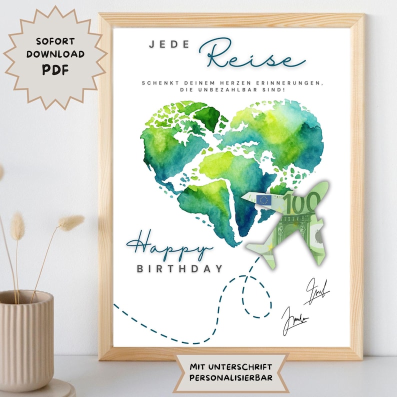 May include: A framed print featuring a watercolour world map heart and a paper airplane made from a 100 Euro note. The words "Happy Birthday" are in blue script. German text is also present on the print.