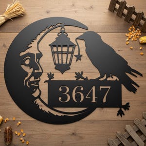 Pode incluir: Arte de parede em metal preto com uma lua crescente com um rosto, uma lanterna suspensa e um corvo. O corvo está pousado em uma placa com o número 3647. Adequado para uso interno ou externo.