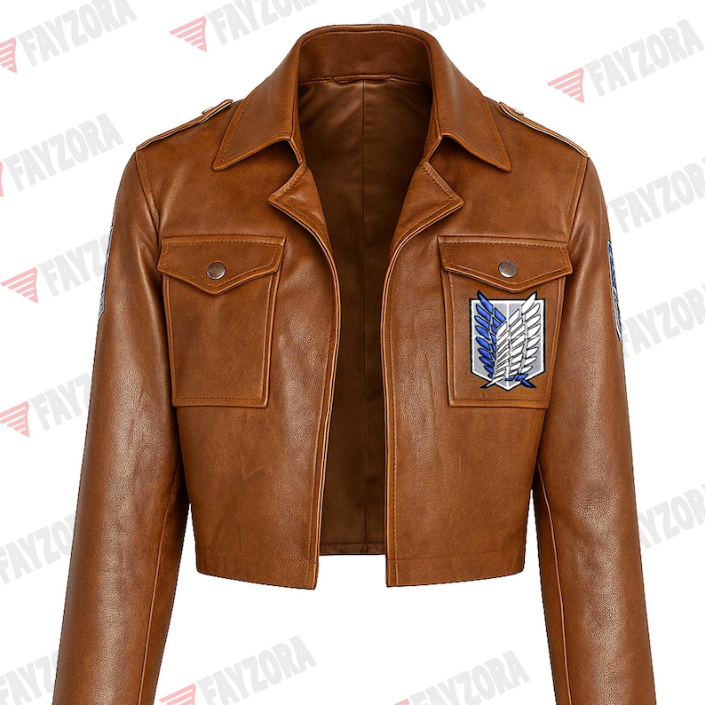 K&ouml;nnte beinhalten: Braune Kunstlederjacke mit kurzem Design. Die Jacke hat einen klassischen Kragen, zwei Vordertaschen und einen Aufn&auml;her mit einem wei&szlig;en, blauen und schwarzen Emblem. Die Jacke hat einen Knopfverschluss und Schulterklappen.