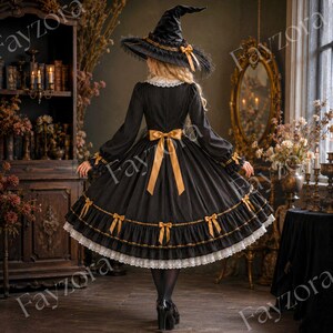 May include: A black long-sleeved dress with a white lace collar, a gold ribbon bow at the waist, and gold ribbon accents on the skirt and sleeves. The dress features a tiered hem with white lace trim and is paired with a matching black witch hat.
